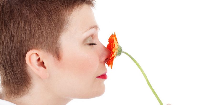 Vrouw ruikt aan bloem