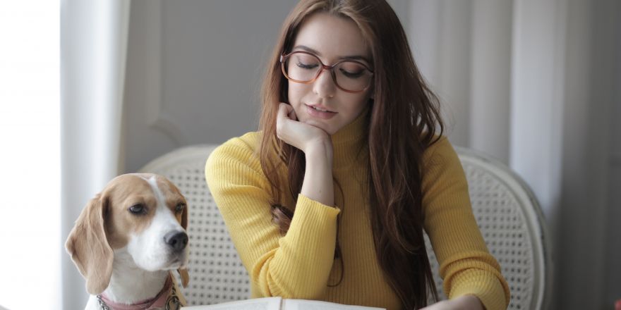 lezend persoon met hond en boek