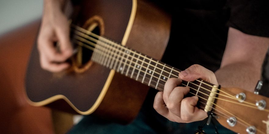 Persoon speelt op een bruine gitaar