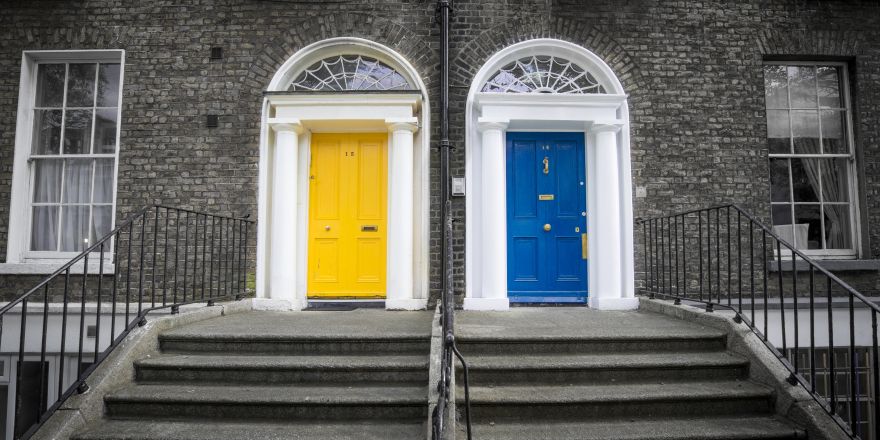 Een gele en een blauwe voordeur naast elkaar