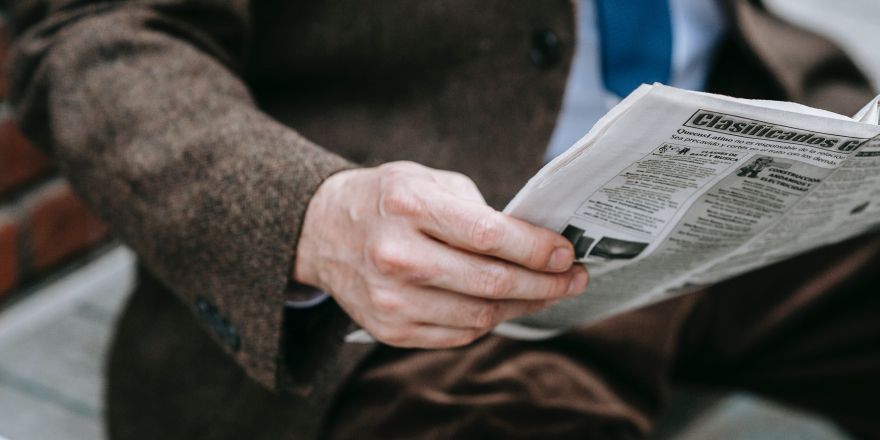 Man leest krant op een bankje