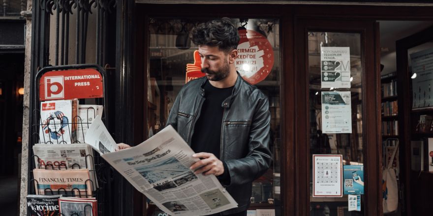 Man leest krant voor de winkel