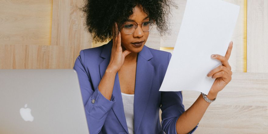 Vrouw kijkt verward naar papier