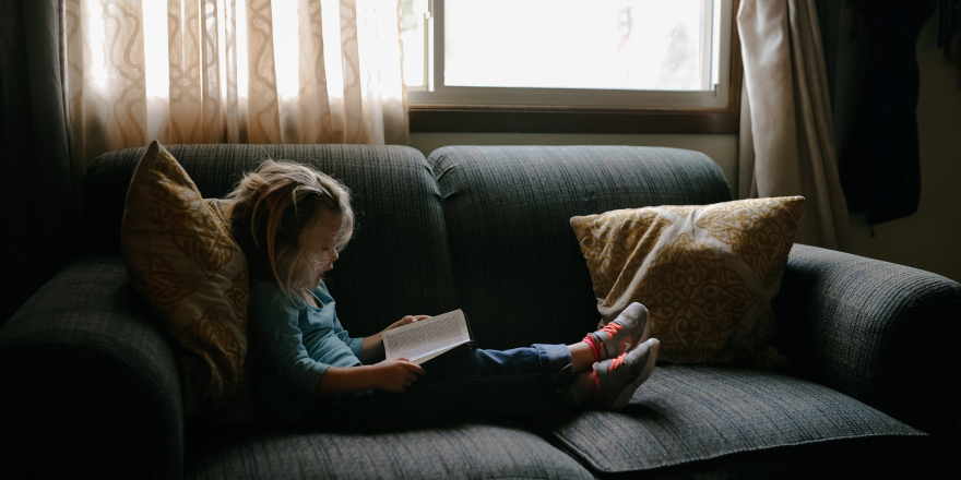 Meisje op bank met boek