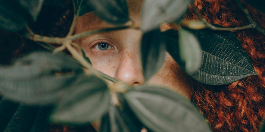 Vrouw verstopt achter bladeren