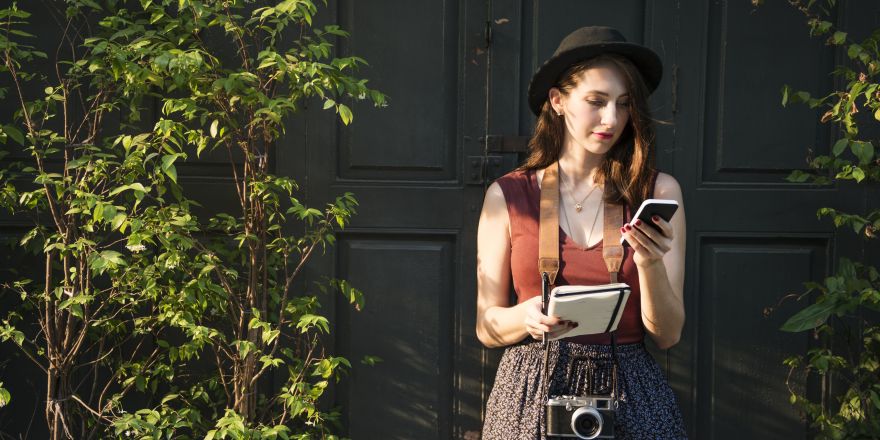 Vrouw met fotocamera en notitieboekje