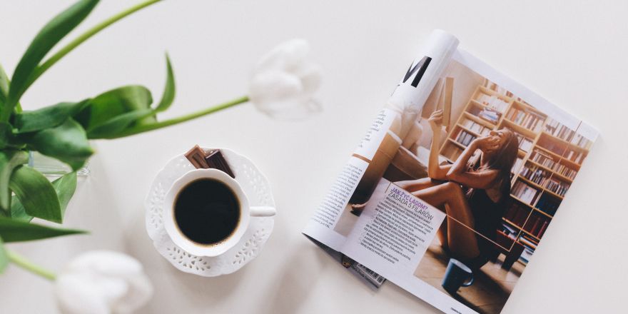Magazine ligt open naast een kop koffie