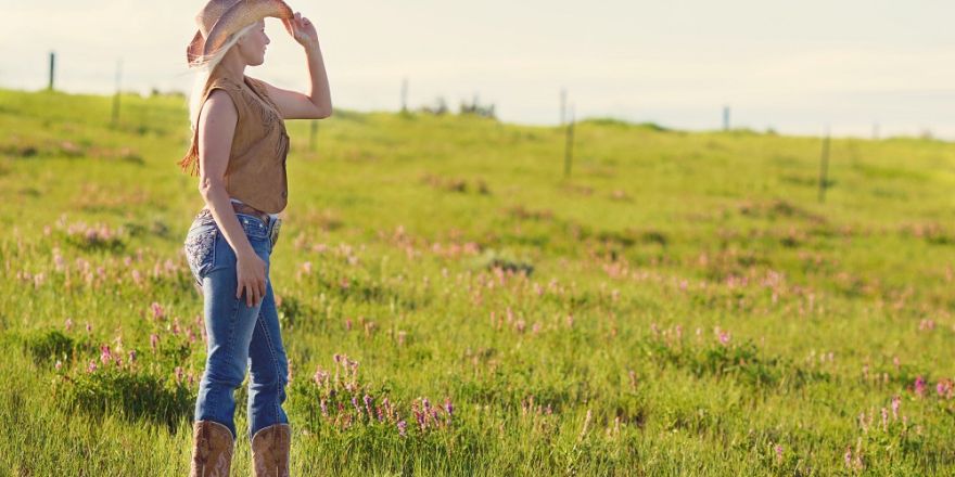 Cowgirl staat in een weiland