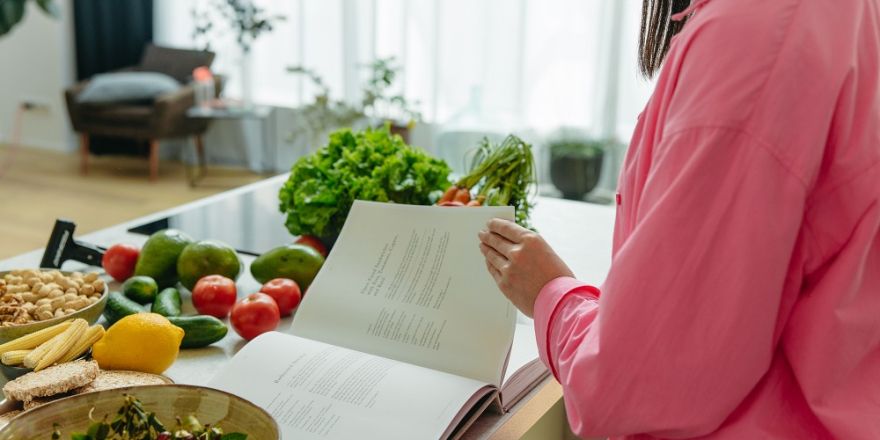 Vrouw bladert door kookboek