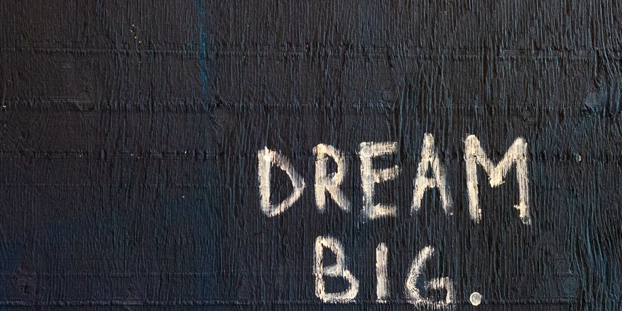 de woorden dream big ofwel droom groot op een muur