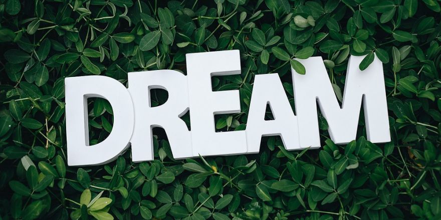 'Dream' in letters tegen een groene achtergrond