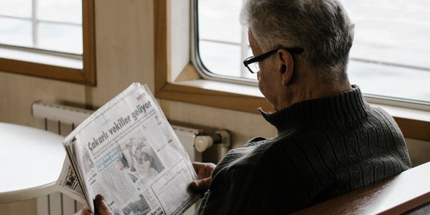 Man leest een krant in de trein.