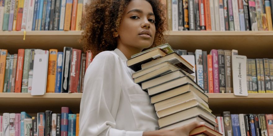 Vrouw draagt stapel boeken