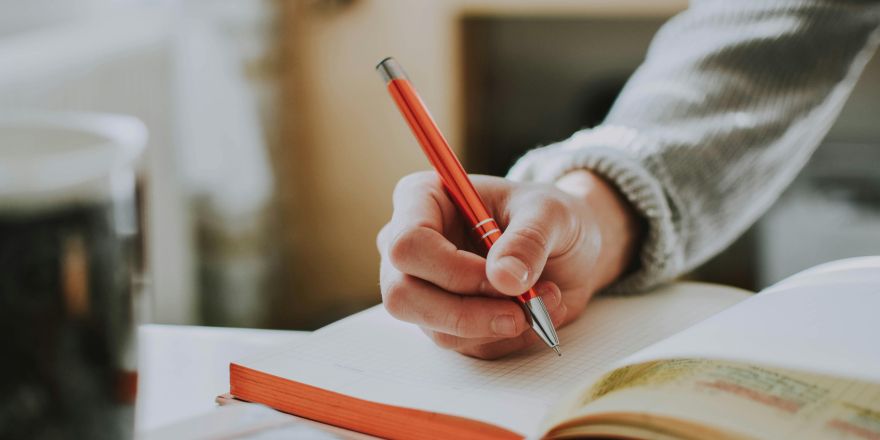 Persoon schrijft in notitieboekje
