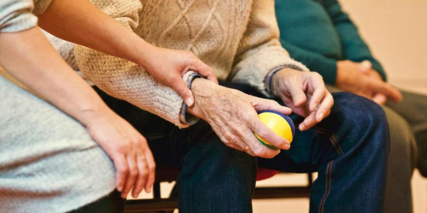 Oud persoon die stress bal in hand heeft