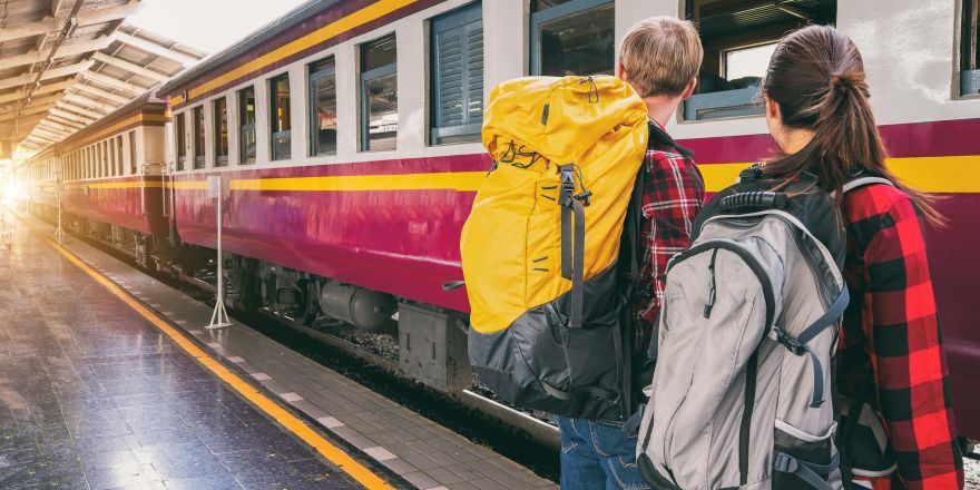 Twee backpackers stappen in de trein