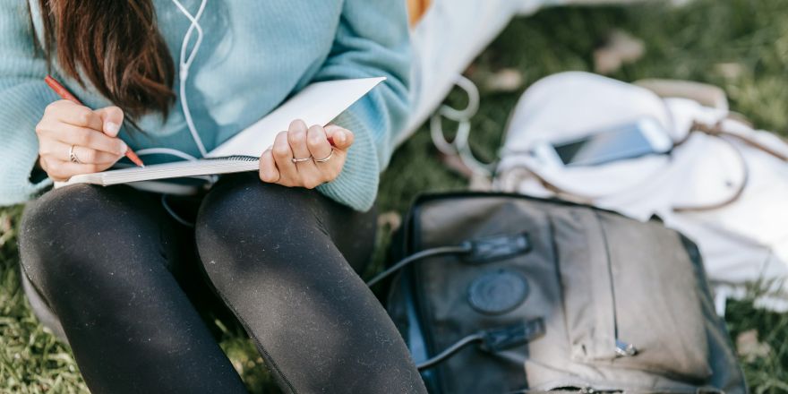 Vrouw schrijft buiten in een notitieboek