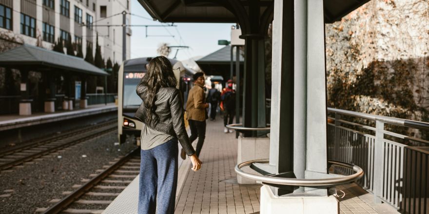 Vrouw In Zwart Jasje En Blauwe Denimjeans Die Zich Op Stoep Bevinden op station