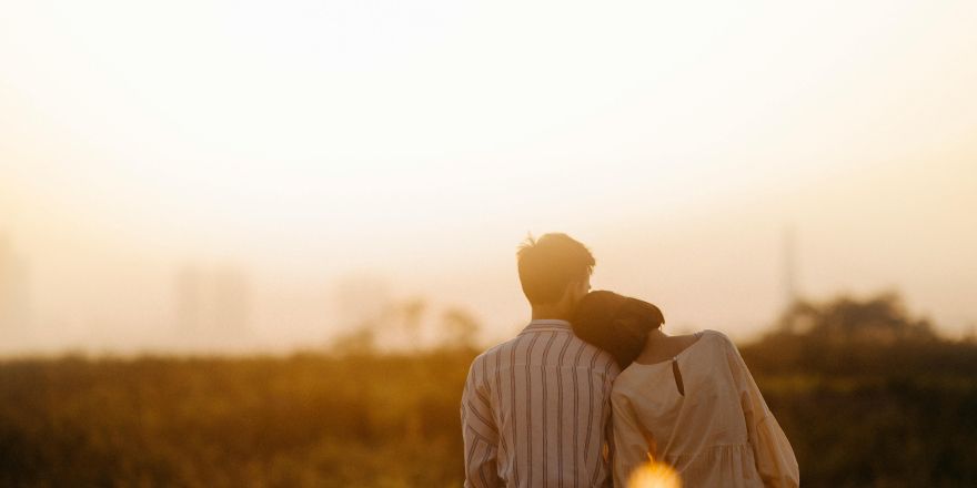 Man en vrouw kijken over de zonsondergang uit