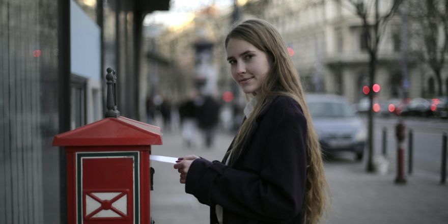 Vrouw doet een brief op de post