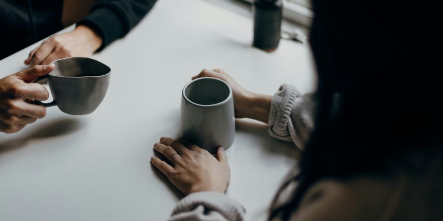 Twee mensen praten terwijl ze koffie drinken
