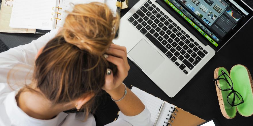 Vrouw werkt gefrustreerd achter haar laptop