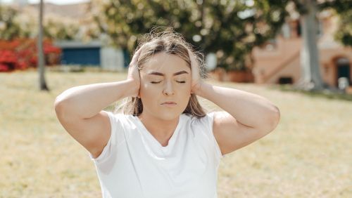 Vrouw drukt handen tegen oren