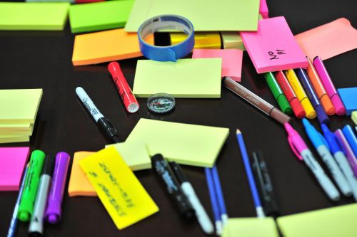 Sticky notes en pennen liggen op een bureau