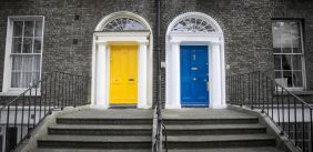 Een gele en een blauwe voordeur naast elkaar