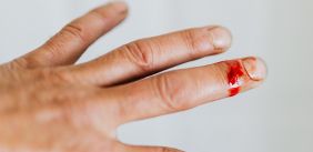 Hand met bloedende middelvinger