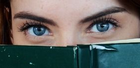 vrouwen ogen kijken over een boek