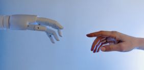 Mensen hand reikt naar een robot hand
