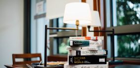 Stapel boeken met een bureaulamp ernaast