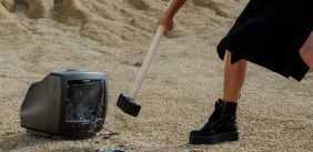 Vrouw slaat oude tv kapot met een hamer