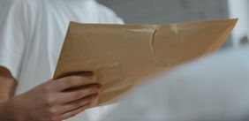 Vrouw houdt grote bruine envelop vast