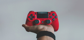 een arm die een rode playstation controller vast heeft