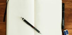 een open notebook met een pen, de pagina's zijn blank, er is nog niet in geschreven
