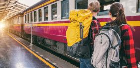 Twee backpackers stappen in de trein