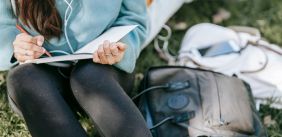 Vrouw schrijft buiten in een notitieboek