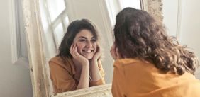 Vrouw kijkt in de spiegel