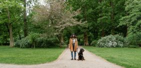 blinde vrouw met blindegeleidestok en blindegeleidehond