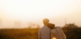 Man en vrouw kijken over de zonsondergang uit