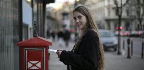 Vrouw doet een brief op de post 