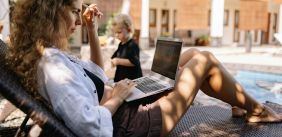 Vrouw schrijft buiten op een laptop