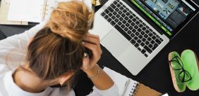 Vrouw werkt gefrustreerd achter haar laptop