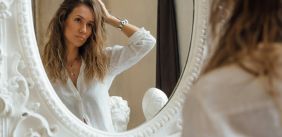 Vrouw kijkt in de spiegel