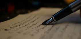 Een vulpen met een notitieboek vol met geschreven woorden