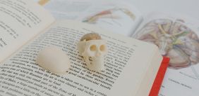 Medisch boek met skelet en medische instrumenten bovenop