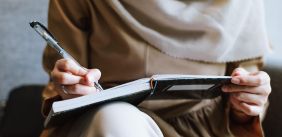 persoon aan het schrijven in een notitieboek