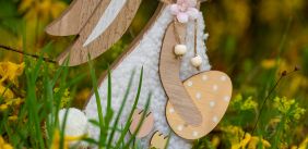 Houten paashaas in tuin met bloemen